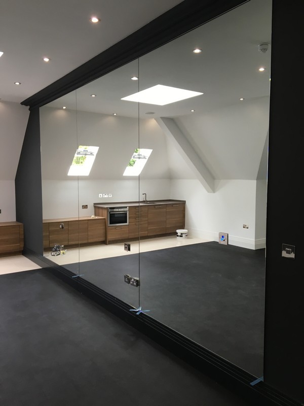 Frameless glass partition in loft conversion by West Drayton glaziers